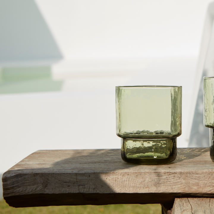 A modern, big, stackable coloured handmade drinking glass in olive green